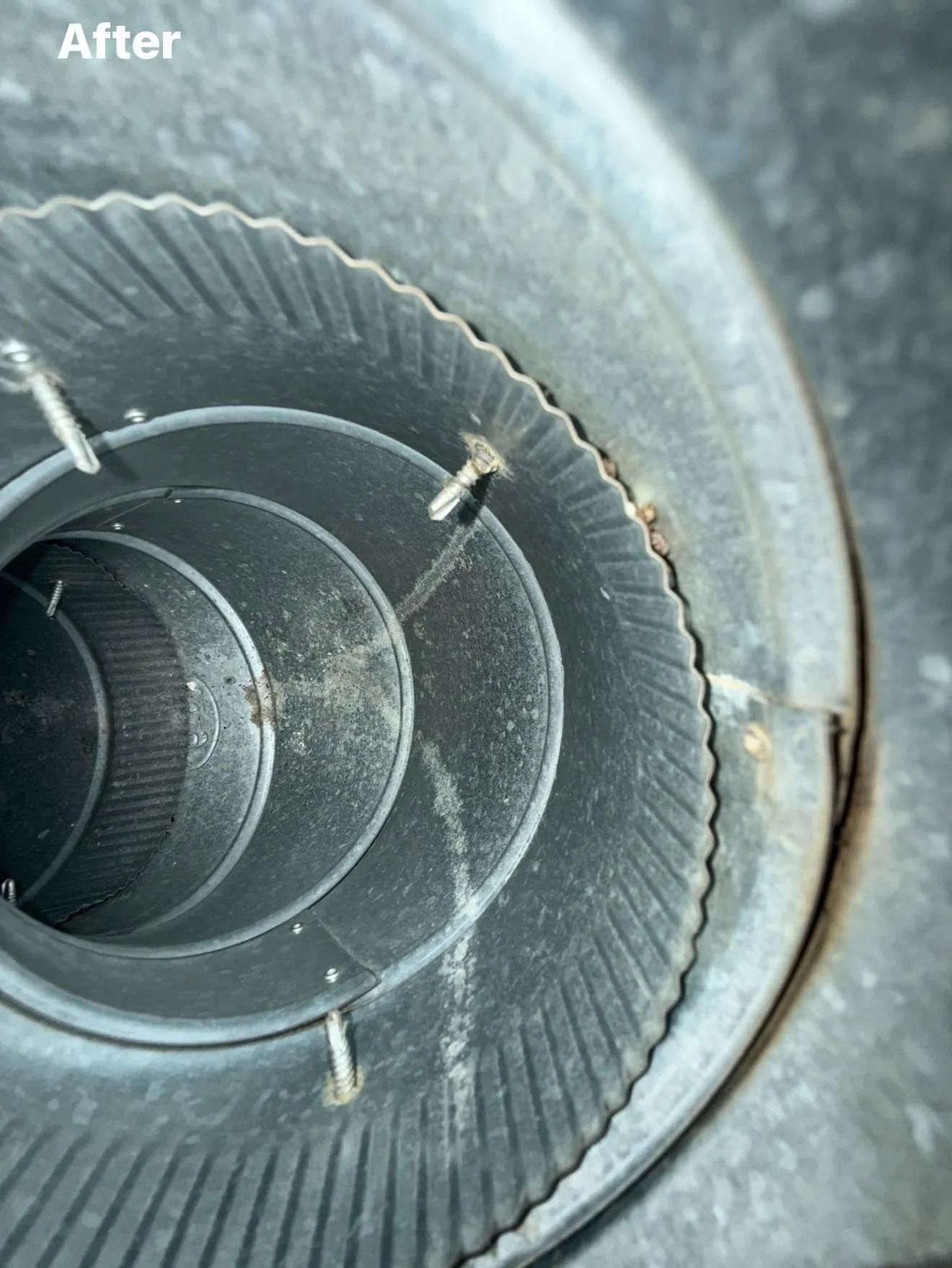 Inside view of a metal duct, showing a cleaned interior with ridges and fasteners. 