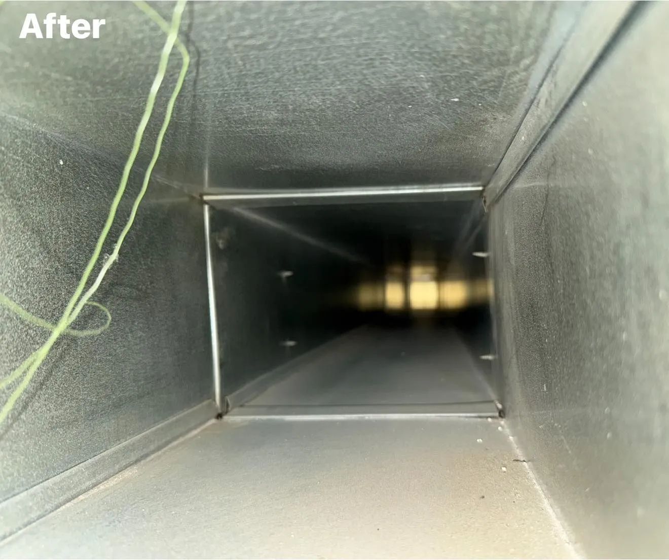 Clean air duct interior, square-shaped, metal, with light reflection. 