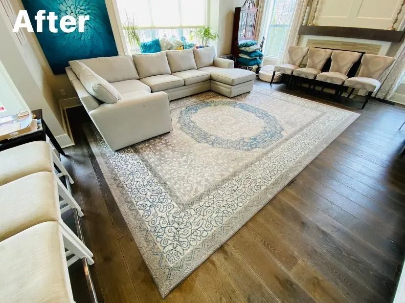 Living room with a large gray sectional sofa on a patterned rug; wood floors.