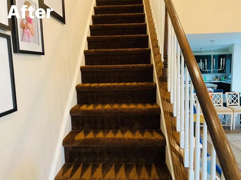 Brown carpeted staircase with white trim and a wooden railing.