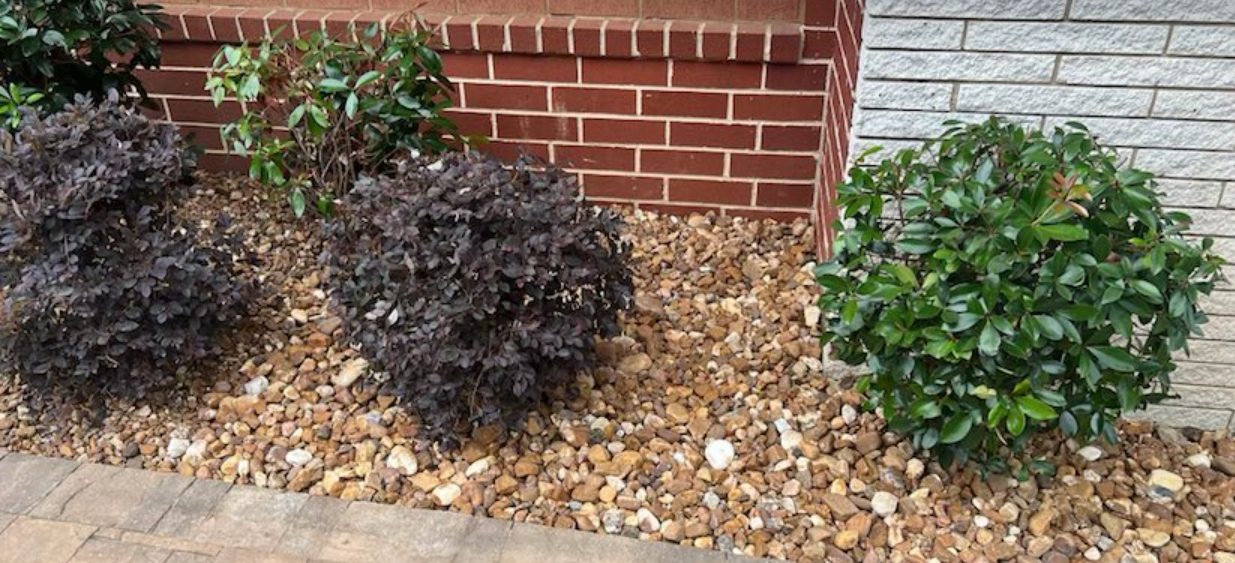 oversized river rock around bushes