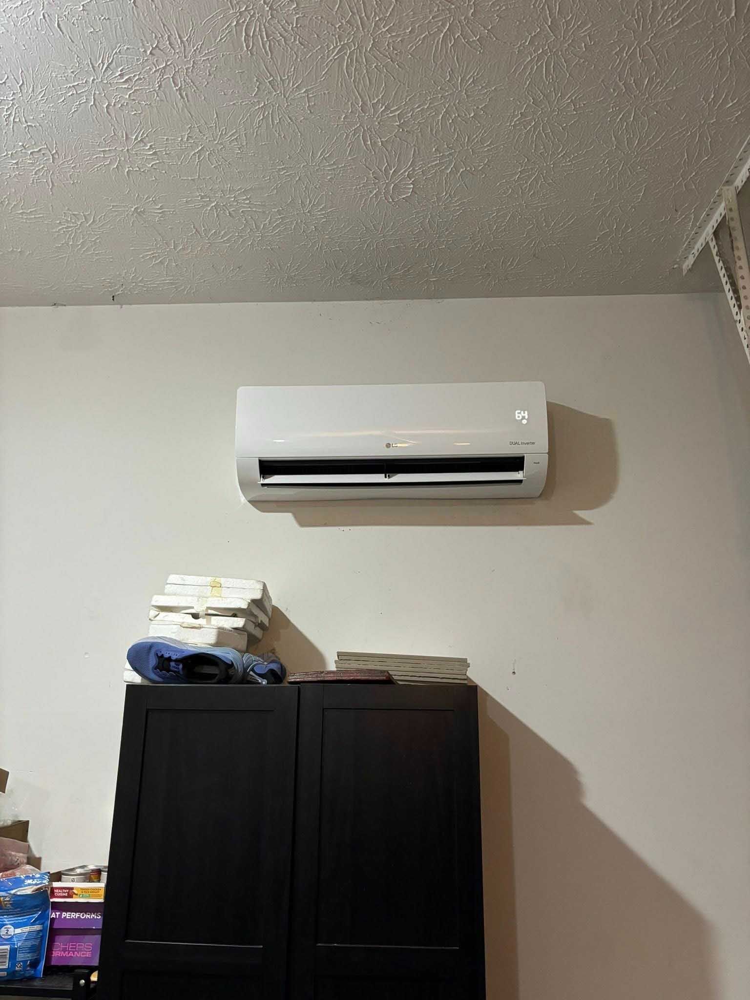 White wall-mounted air conditioner above a dark closet. The ceiling is textured.