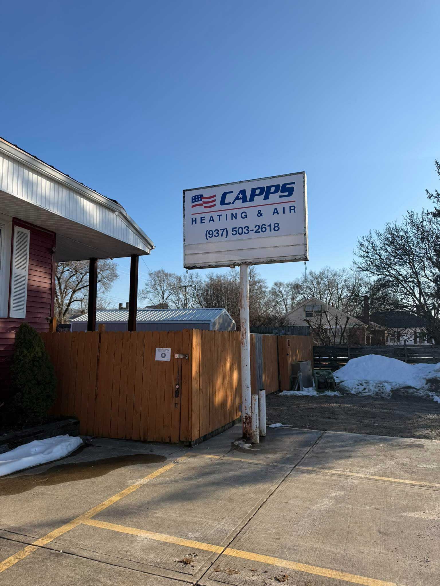 Sign for Capps Plumbing & Drain in front of a building on a sunny day.