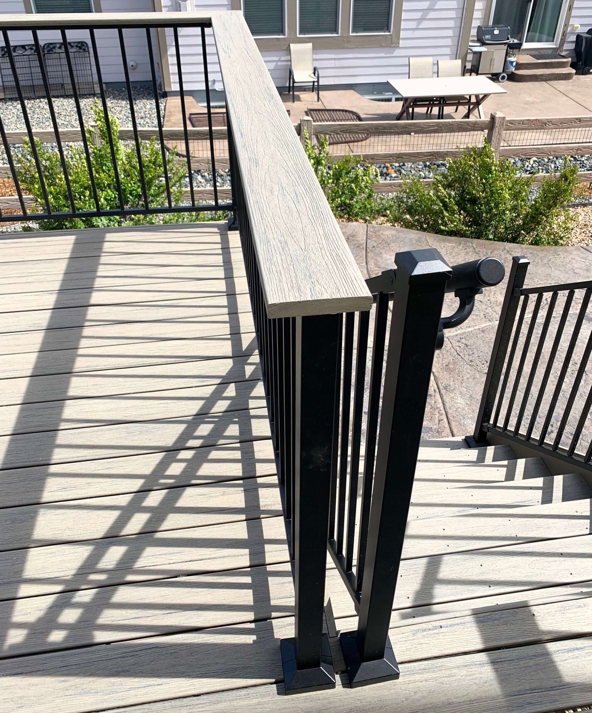 Composite deck with black railing and light gray top rail.