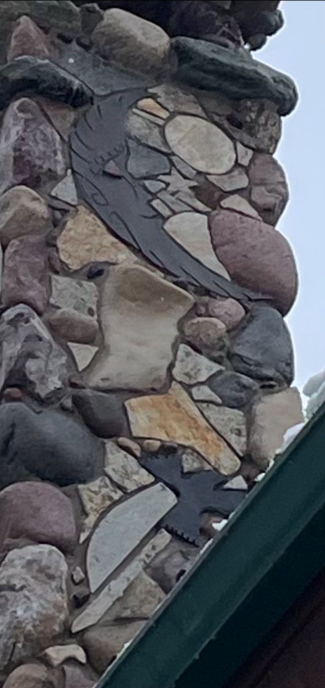 A close up of a stone chimney with a bird and moon design on it