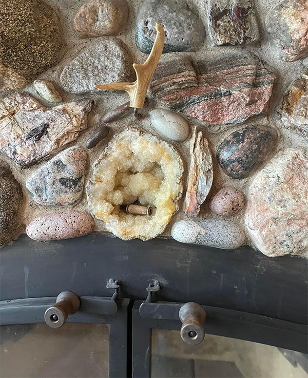 A fireplace surrounded by rocks and deer antlers.