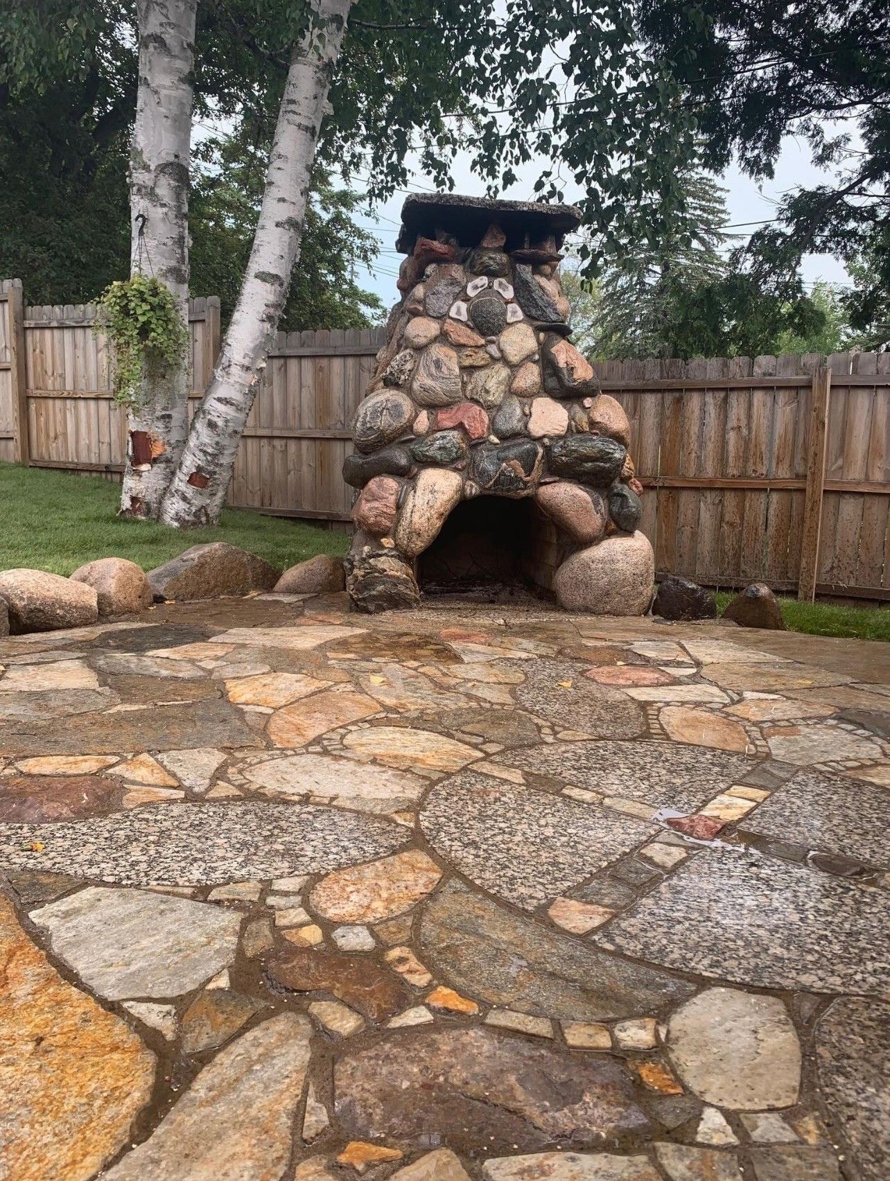 A stone fireplace is sitting on top of a stone patio