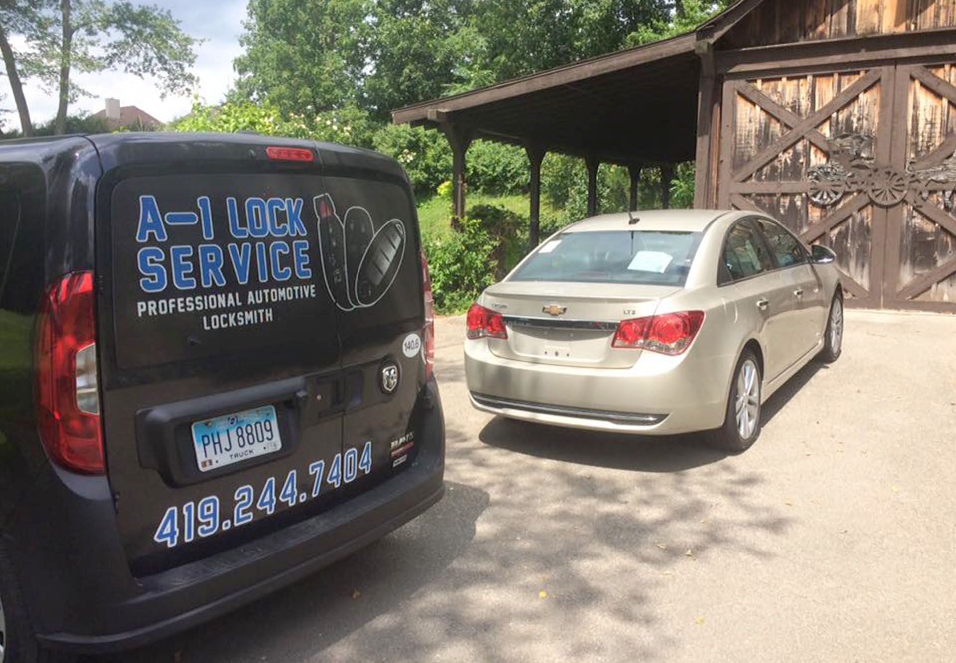 A-1 Lock Service black van and a car parked in front of a barn