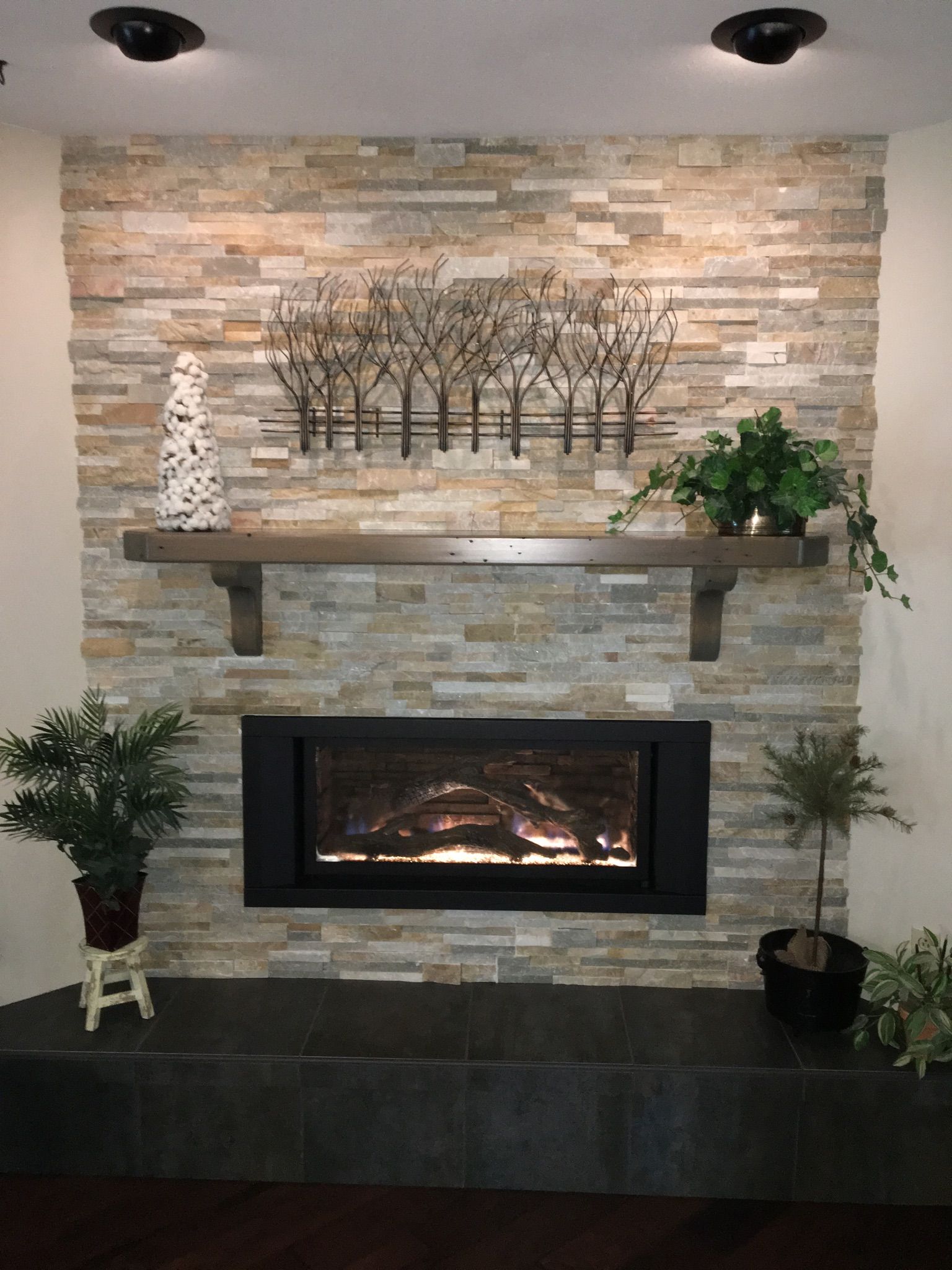A living room with a fireplace and a stone wall