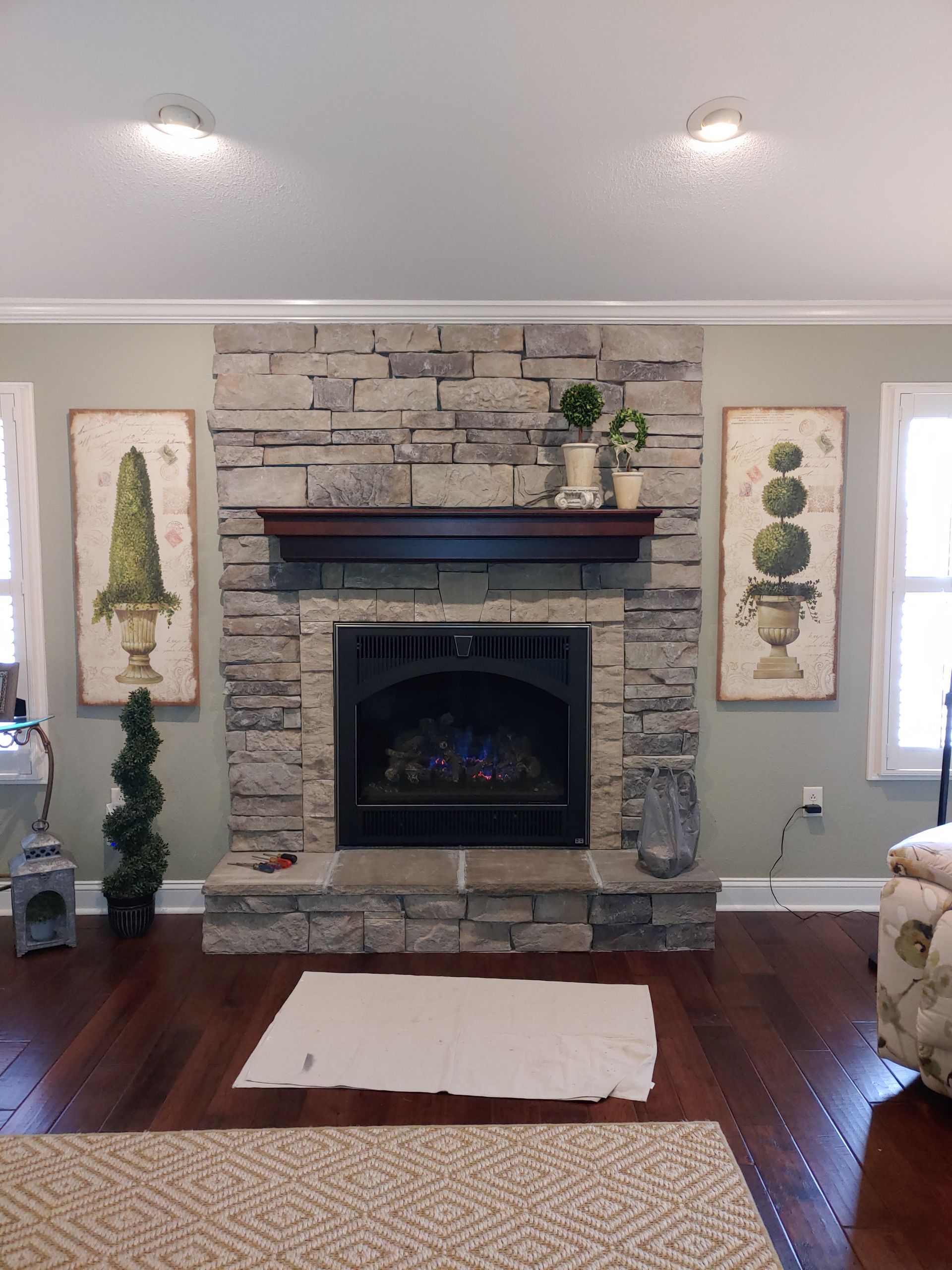 A living room with a fireplace and two pictures on the wall.