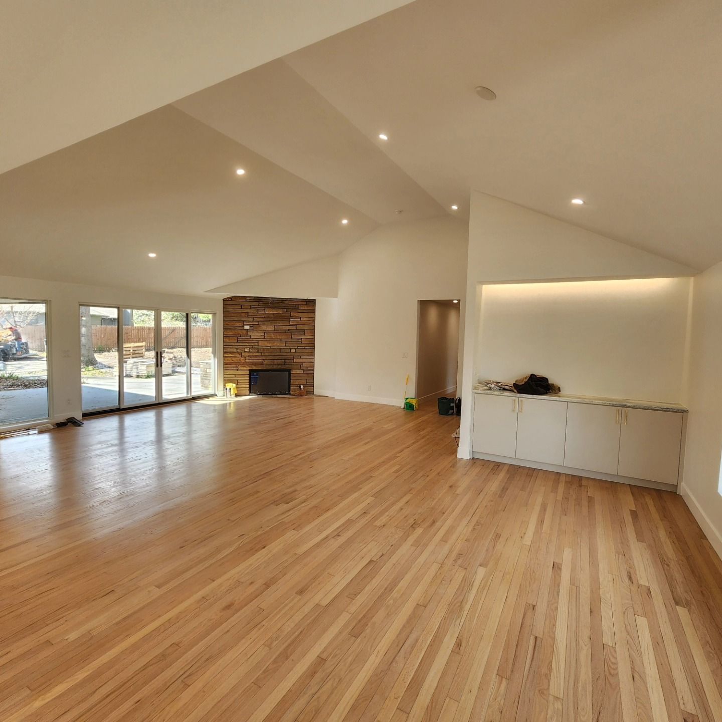 An empty living room with hardwood floors and a fireplace