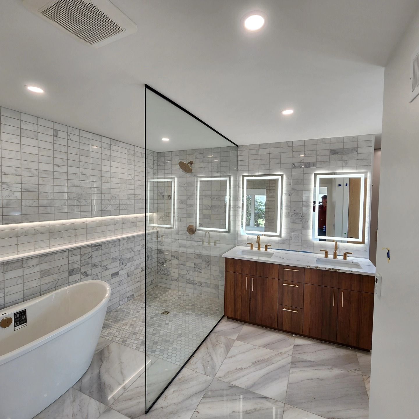 A bathroom with a bathtub and a walk in shower