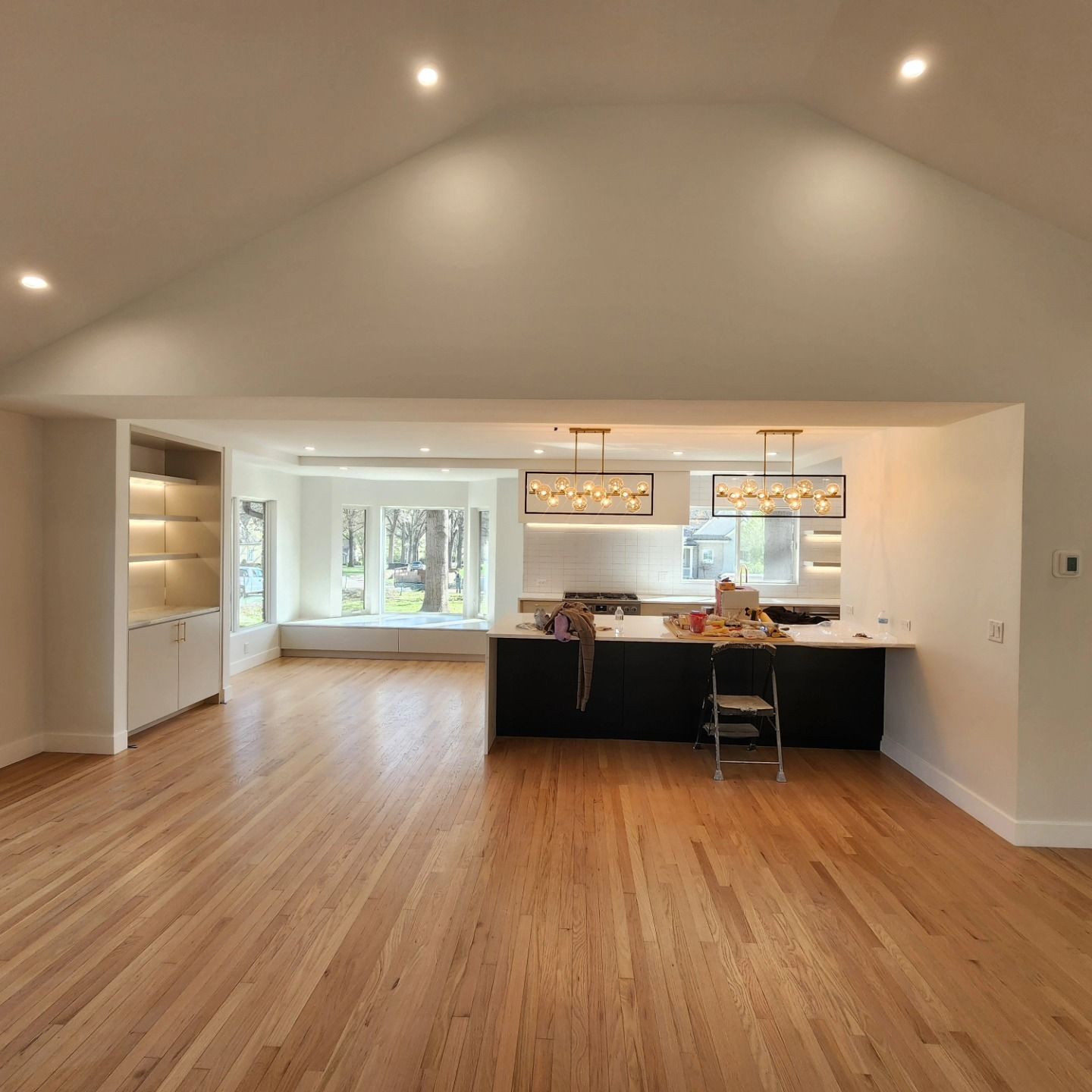 A kitchen with a vaulted ceiling and hardwood floors