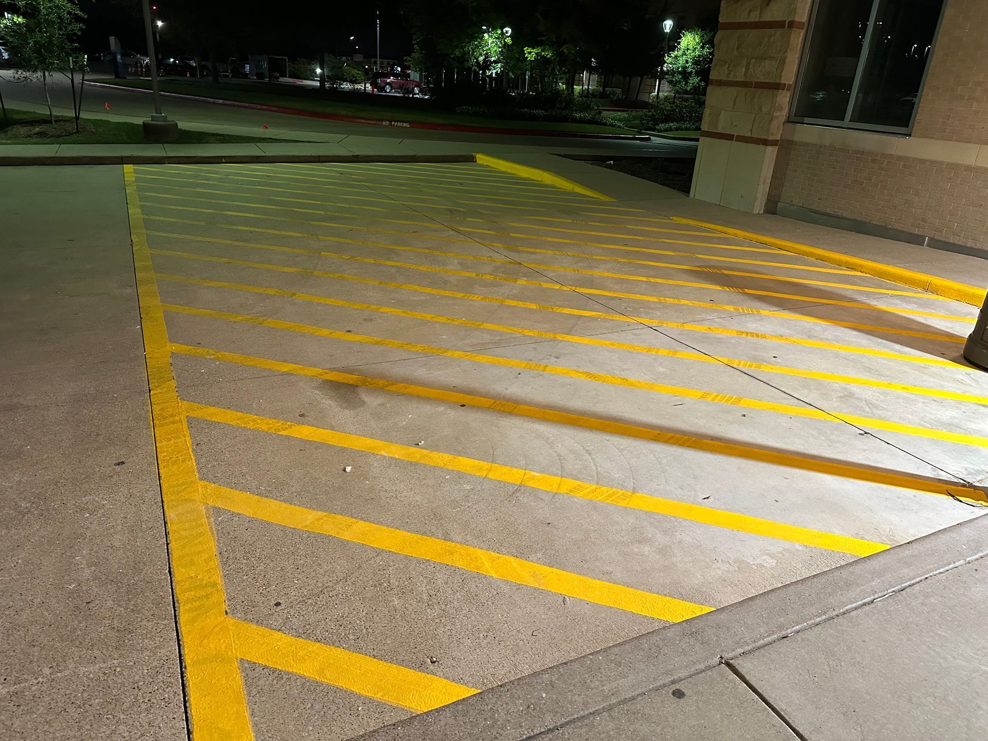A parking lot with yellow lines painted on it at night.