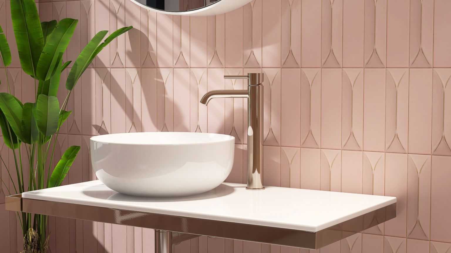 A white vessel sink with a modern faucet sits on a white counter against a wall of geometric pink tiles with a plant.