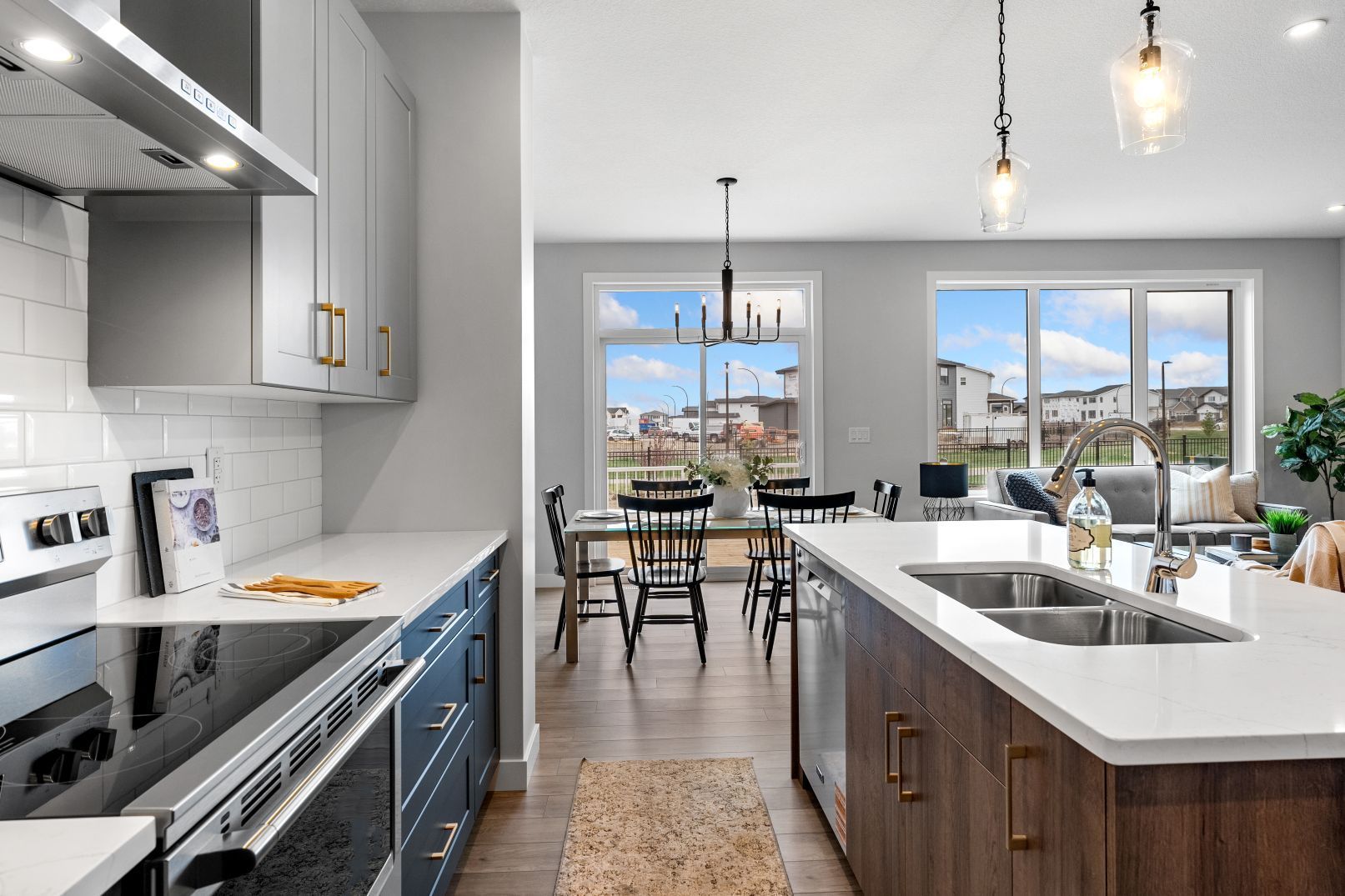 Modern kitchen with a gray island, dark wood cabinetry, stainless steel appliances, and an open dining area.