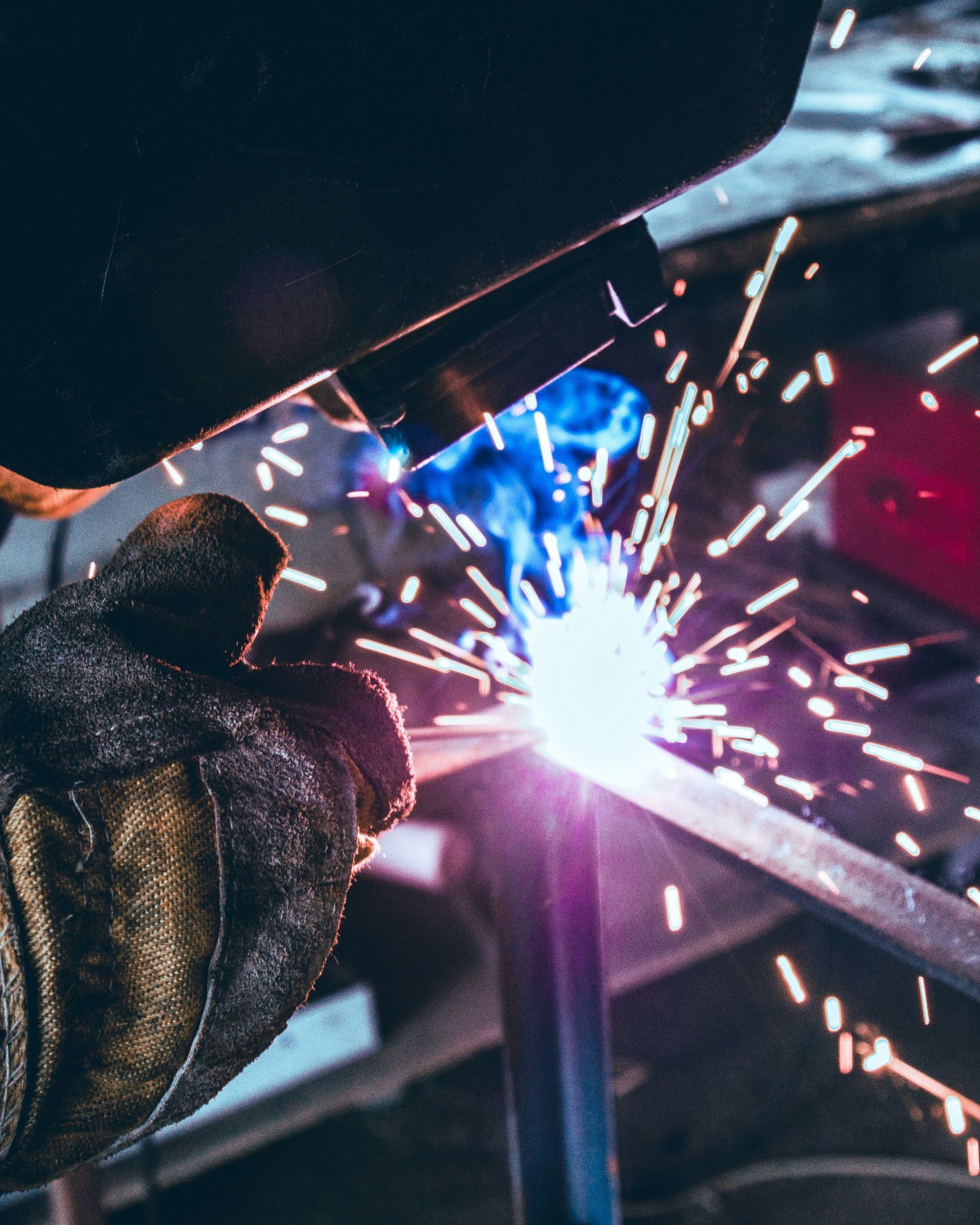 A person is welding a piece of metal with sparks coming out of it.