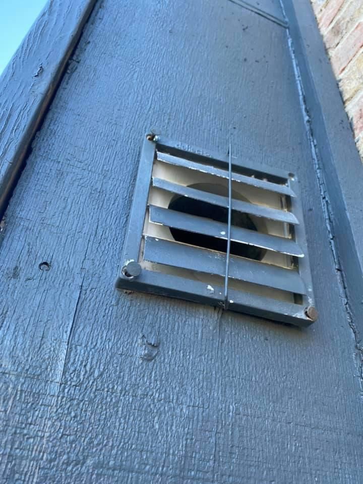 Gray vent on a painted gray wooden wall.