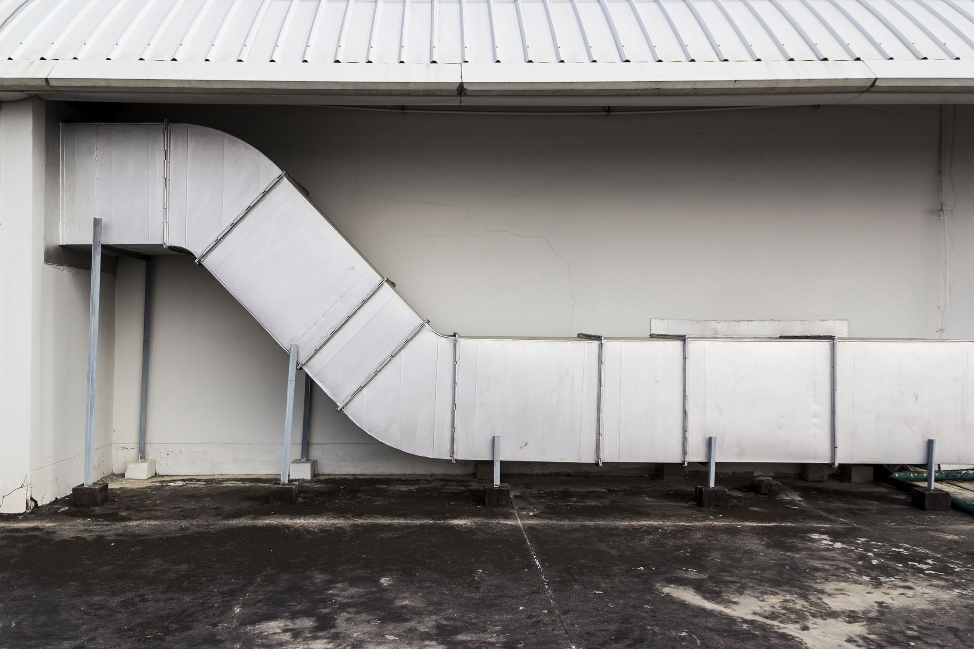 Large, rectangular HVAC unit on a rooftop, with black mesh sides and dark exhaust vents. A control panel is visible.