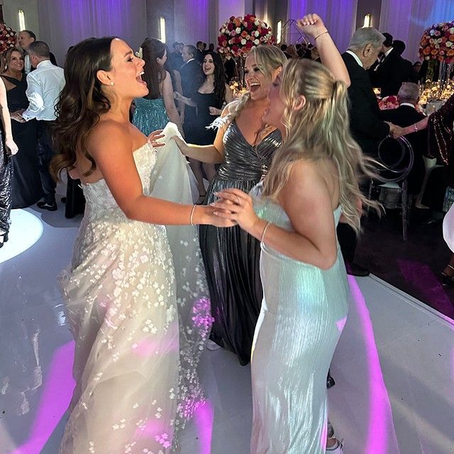 A group of women are dancing at a wedding reception
