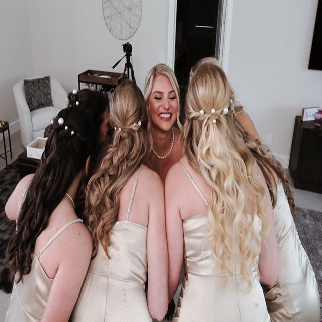 A bride and her bridesmaids are posing for a picture