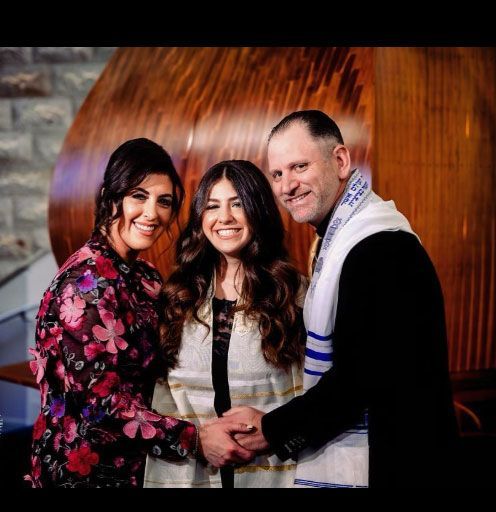 A man and two women are posing for a picture together.
