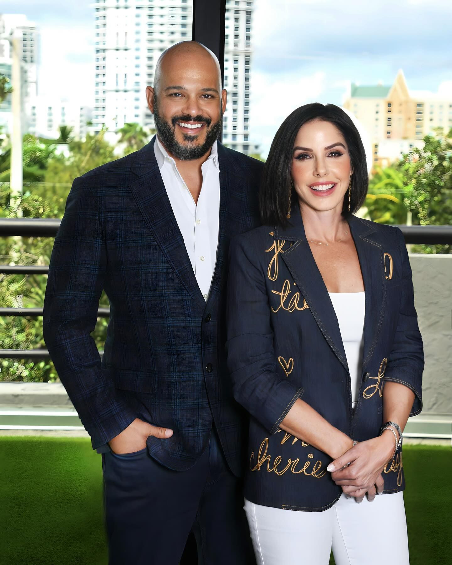 A man and a woman are standing next to each other on a balcony.