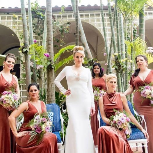 A bride and her bridesmaids are posing for a picture
