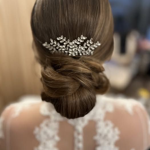 The back of a woman wearing a wedding dress and a bun with a comb in her hair.