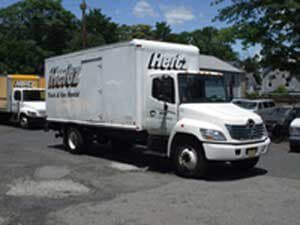 A white box truck is parked on the side of the road