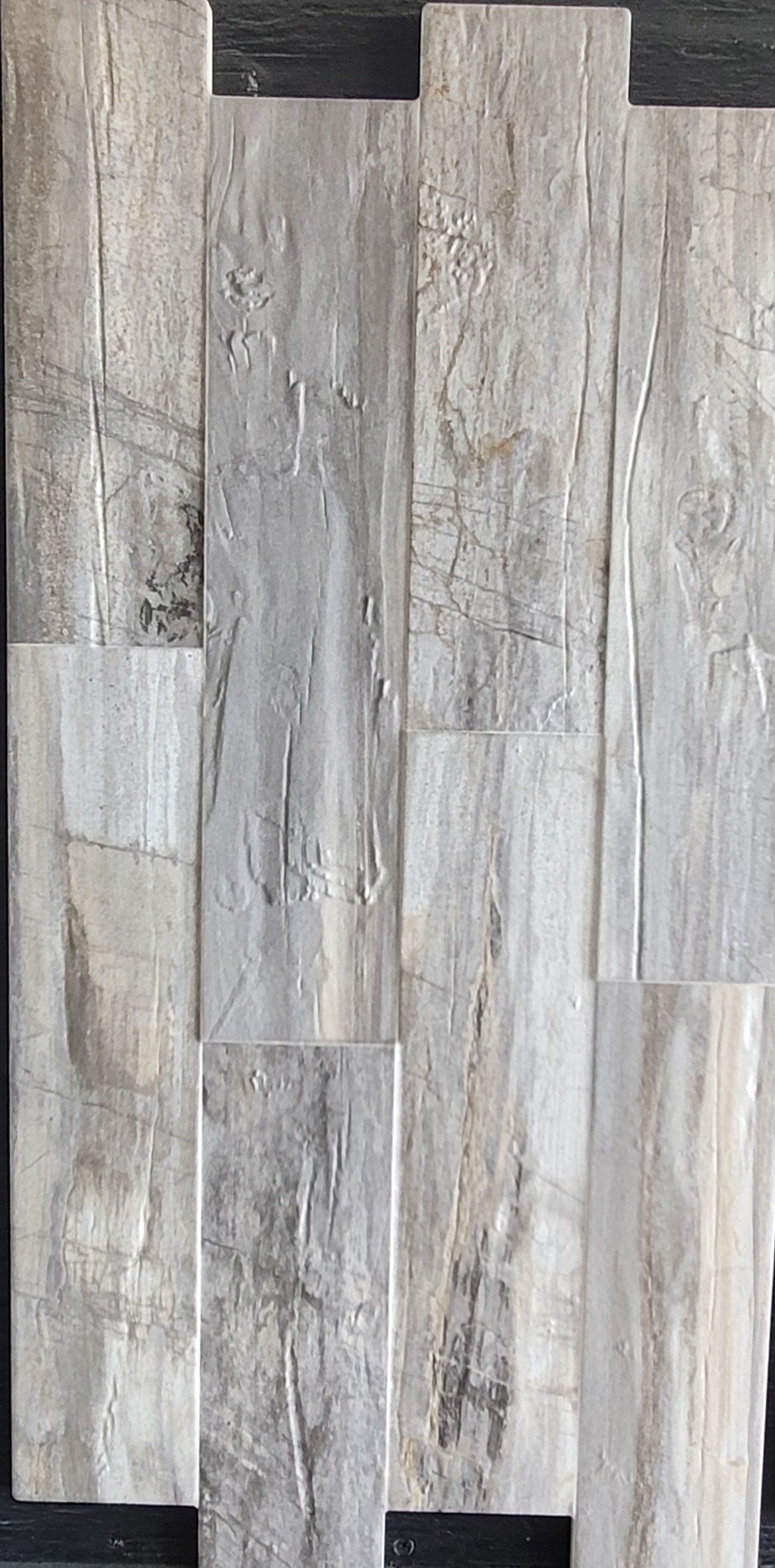 A close up of a gray tile that looks like wood.