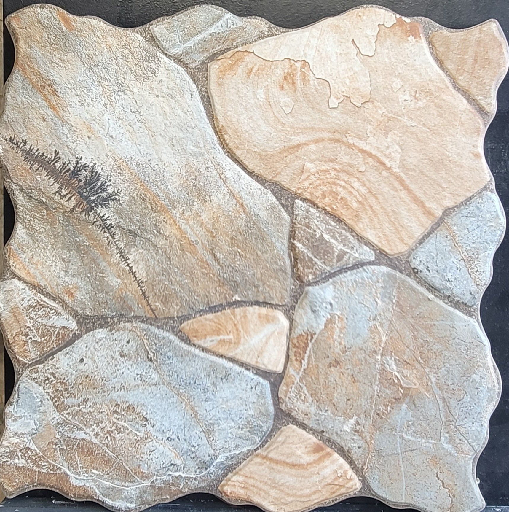 A tile that looks like a rock is sitting on a black surface.