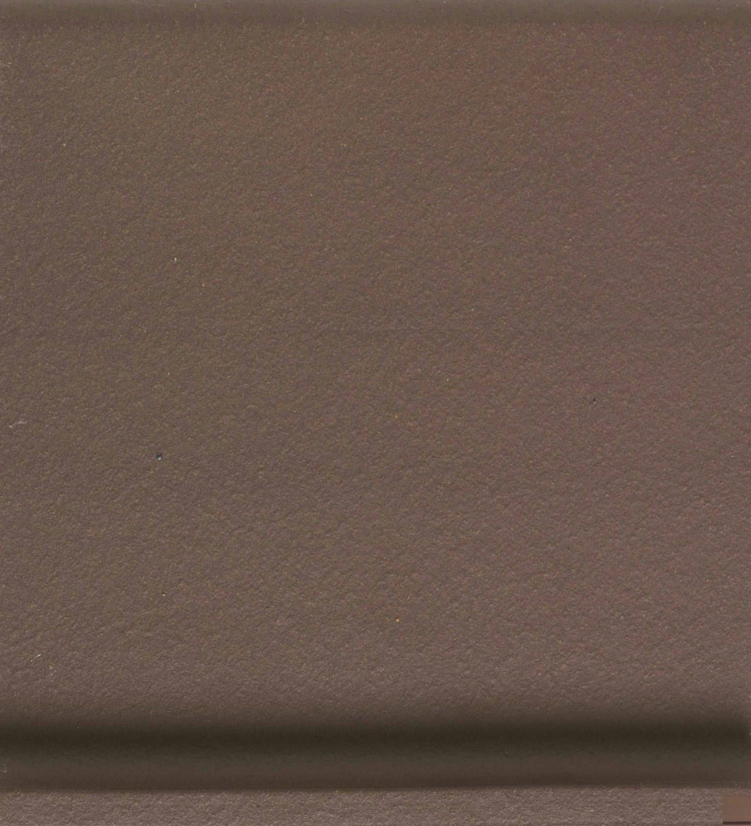 A close up of a brown tile with a grainy texture.