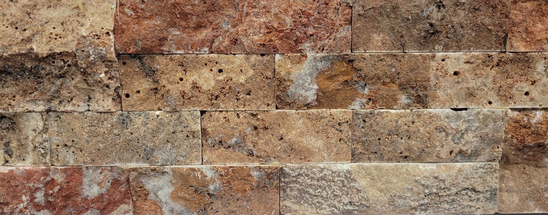 A close up of a stone wall with a brick pattern
