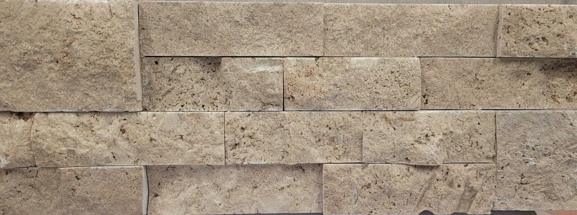 A close up of a brick wall with a few bricks missing