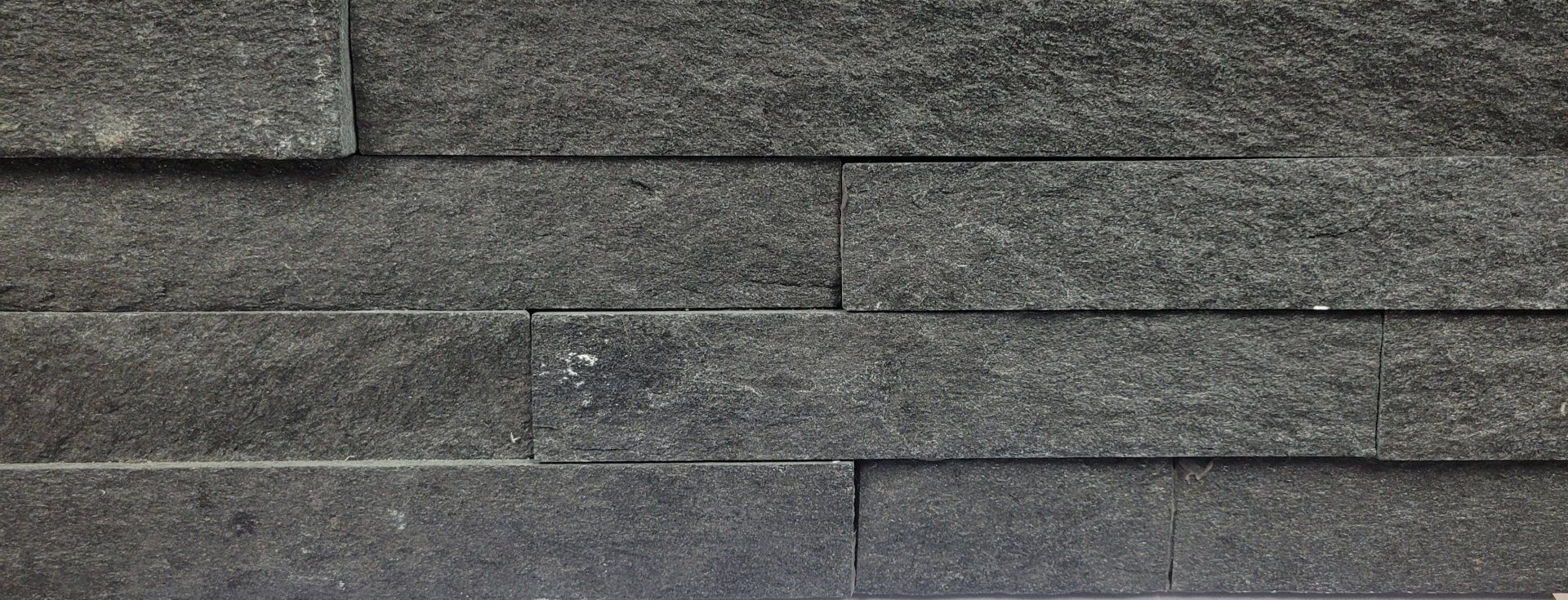 A close up of a black brick wall.