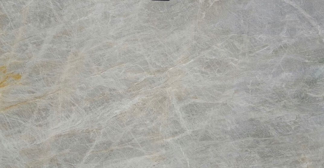 A close up of a white marble tile with a marble texture.