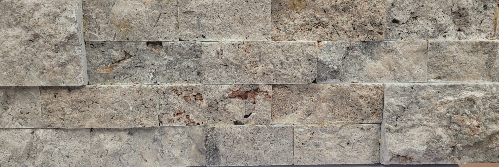 A close up of a brick wall with a lot of bricks on it.