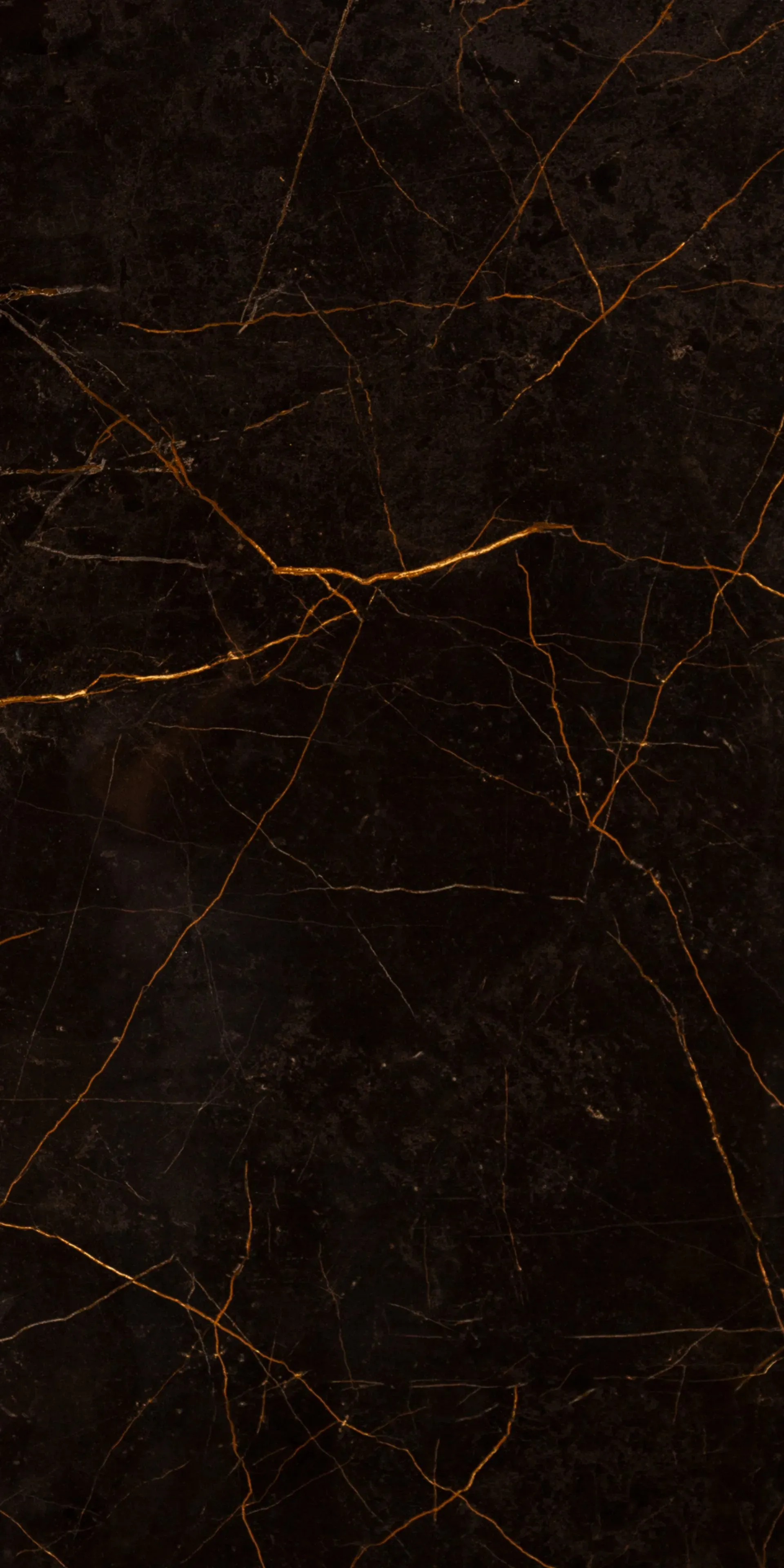 A close up of a black marble tile with gold veins.