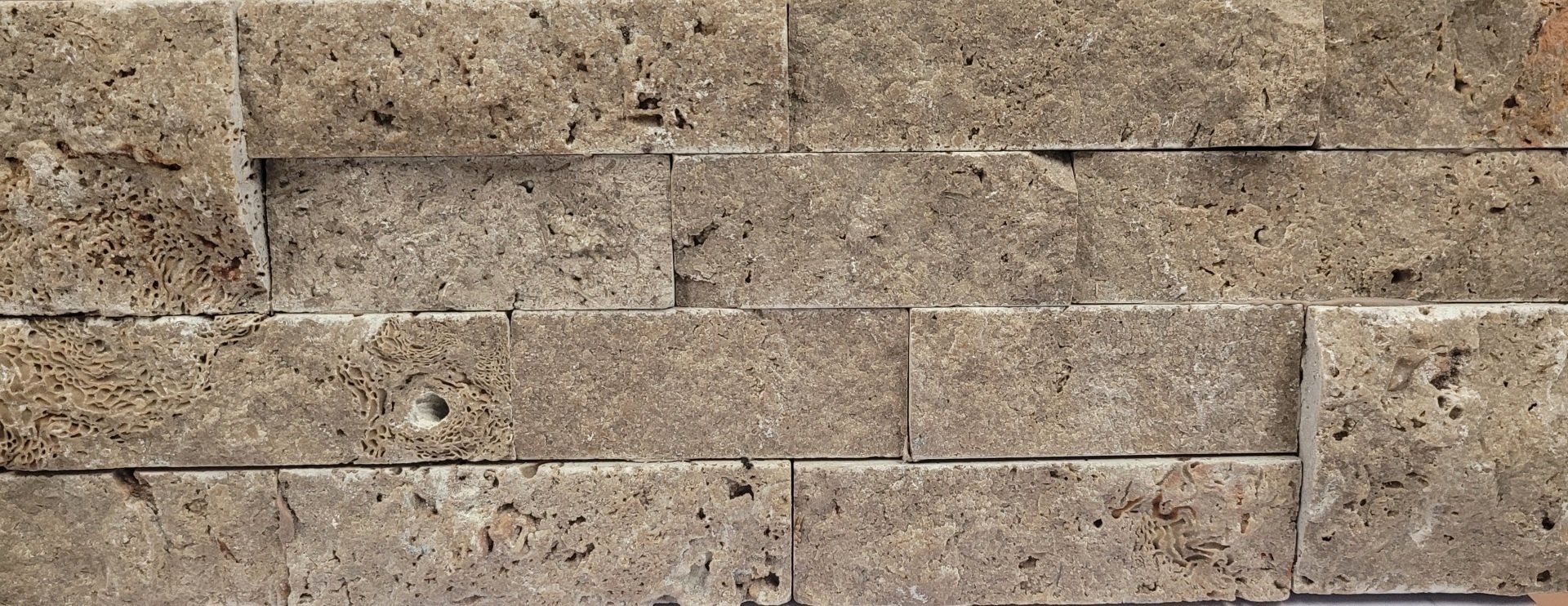 A close up of a brick wall with a lot of bricks on it.