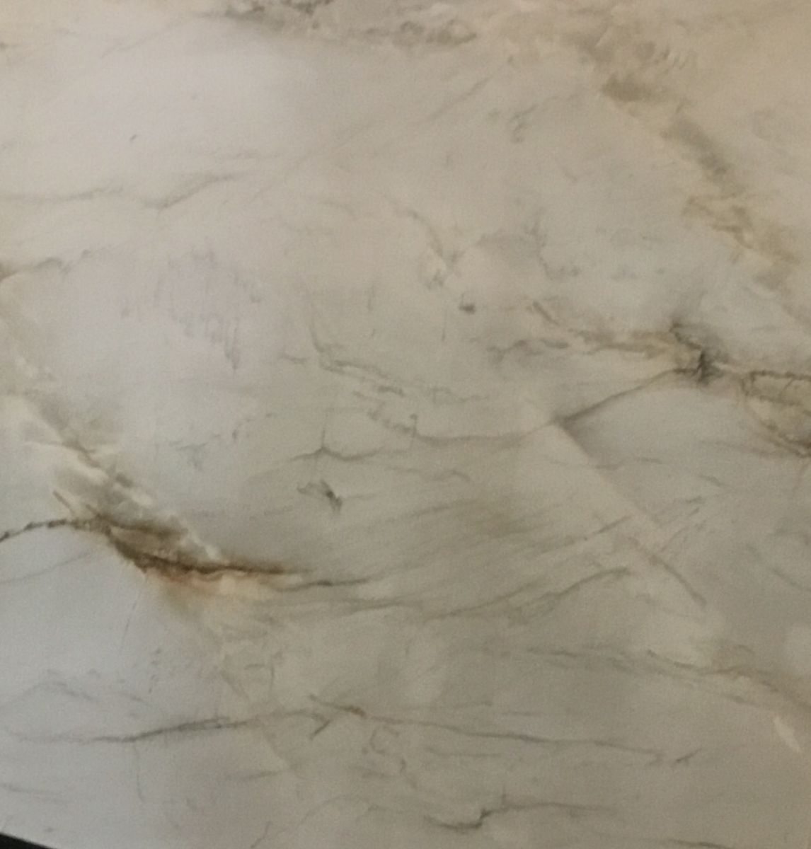 A close up of a white marble counter top.