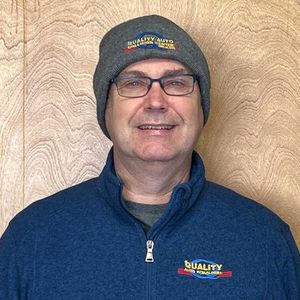 Man in glasses and beanie, wearing a blue jacket with 