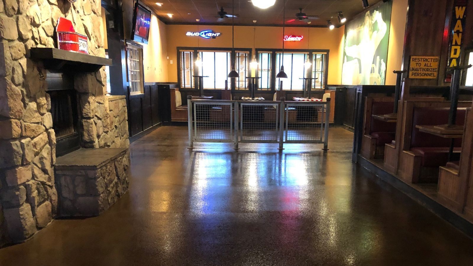 An empty restaurant with tables and chairs and a fireplace.