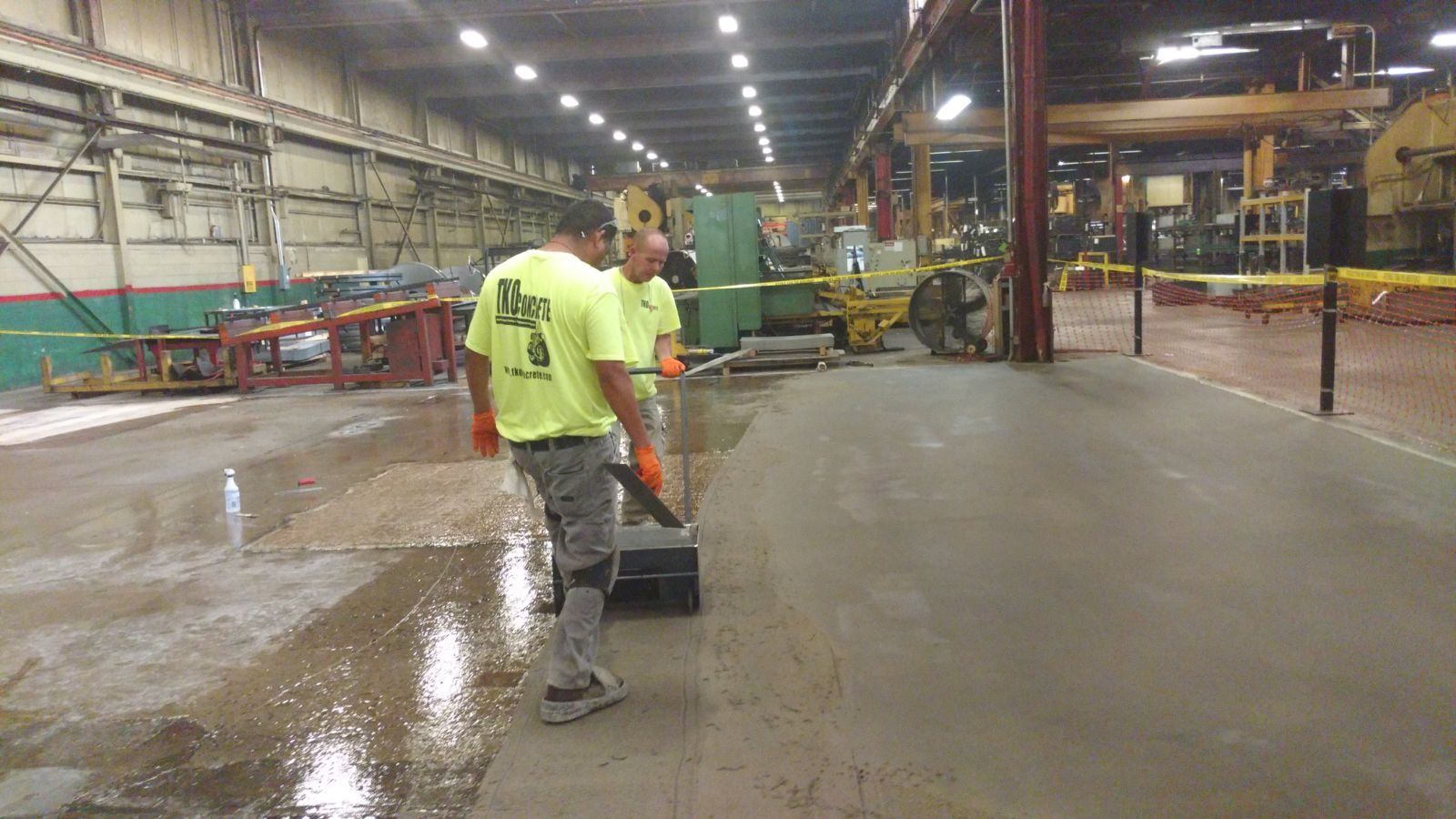 A group of men are standing in a large warehouse.