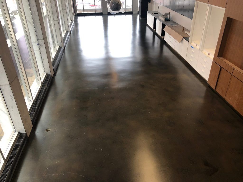 A long hallway with a shiny concrete floor and a lot of windows.