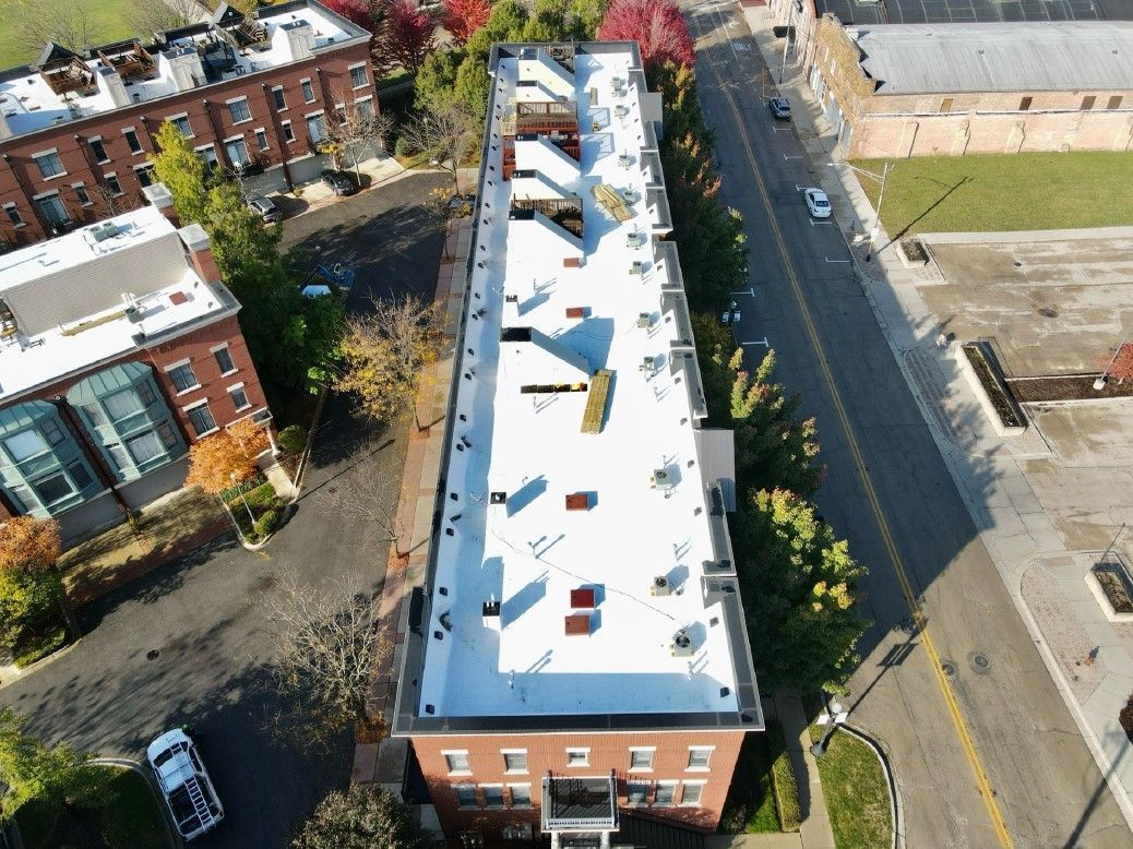 An aerial view of a large building with a white roof
