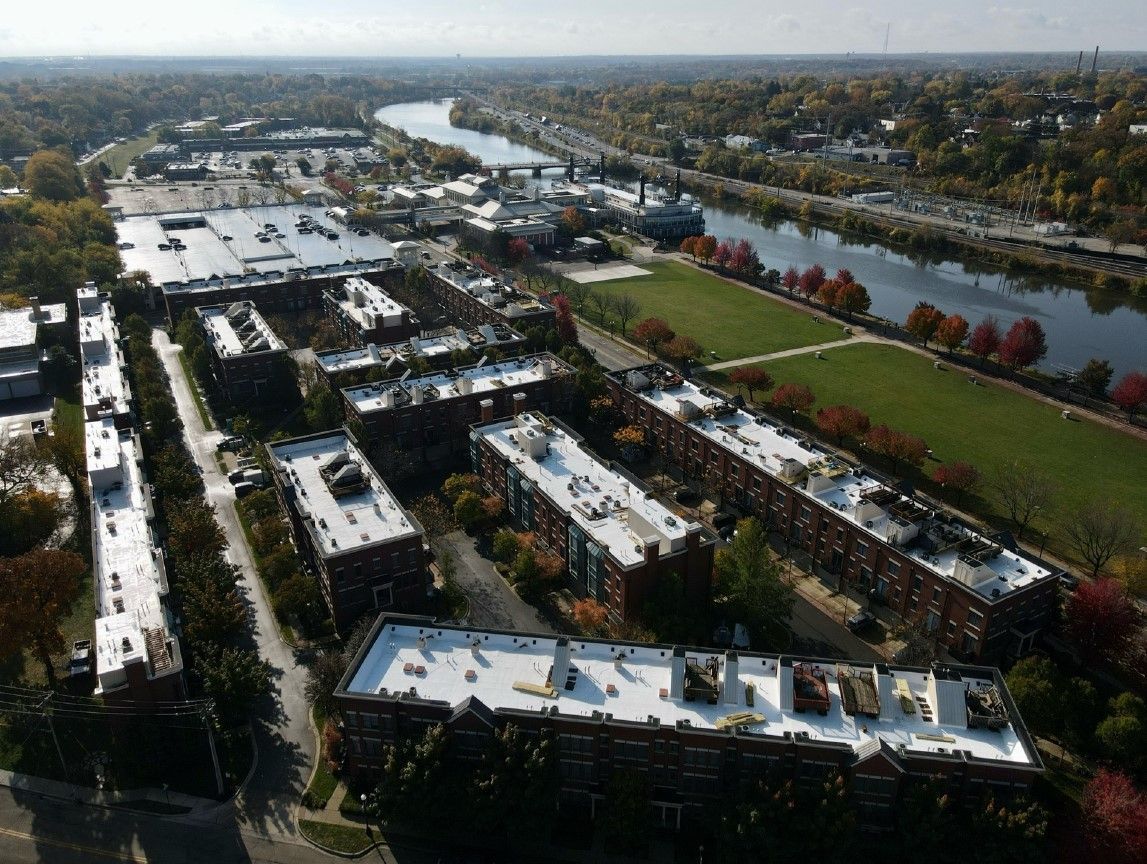 An aerial view of buildings with a river in the background