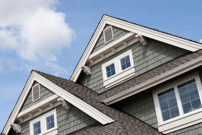 The roof of a house with a blue sky in the background