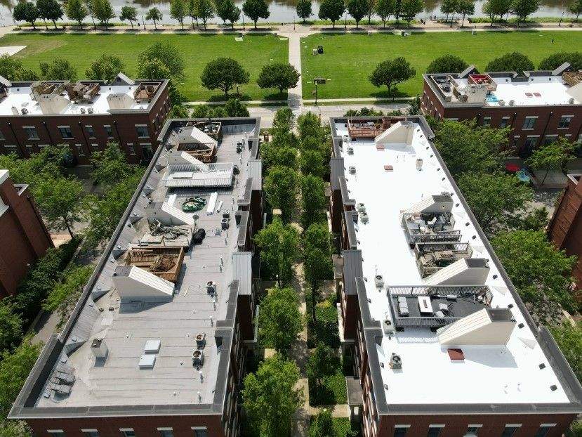 An aerial view of two buildings, one of which is undergoing roof repair or replacement