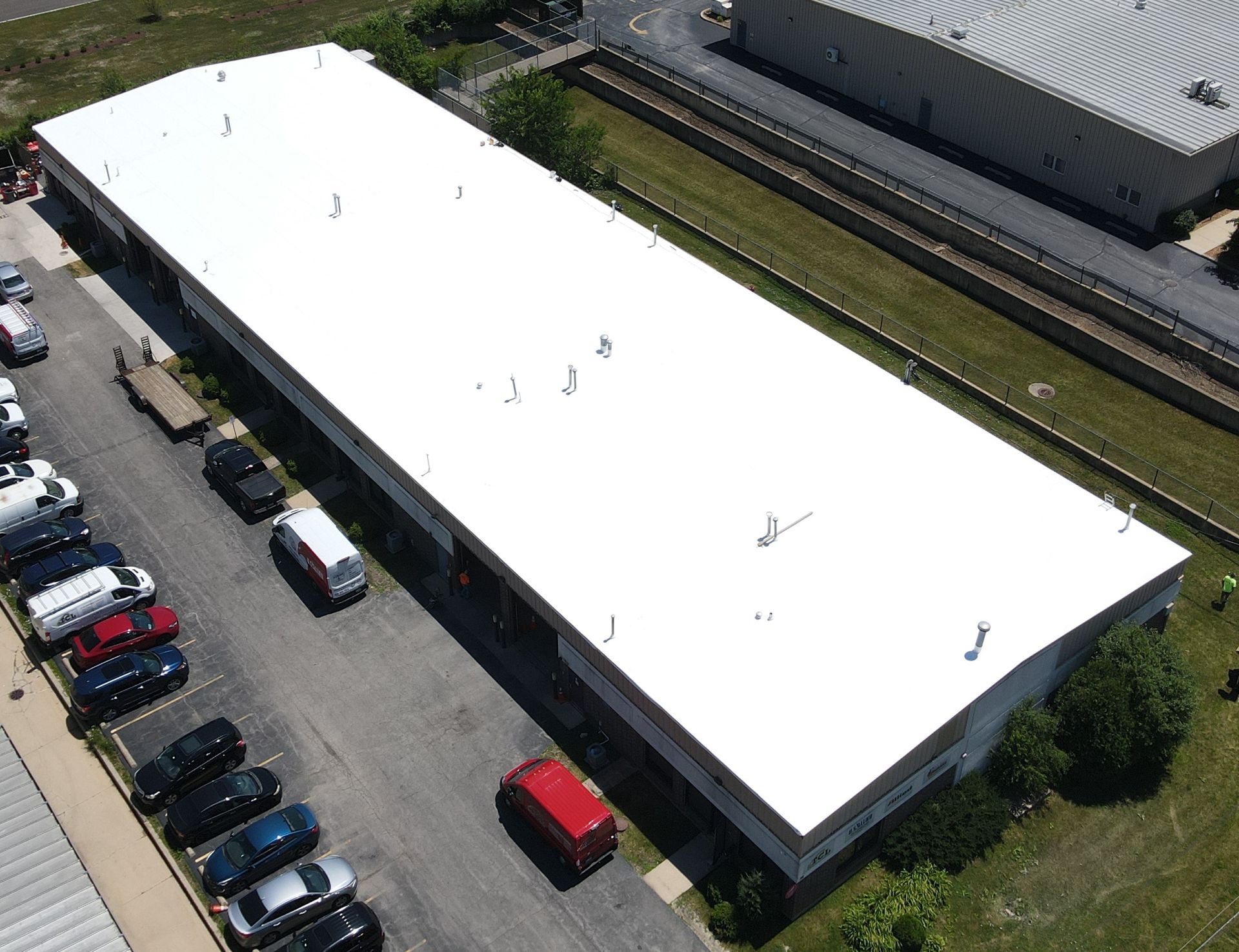 An aerial view of a large building with a white roof